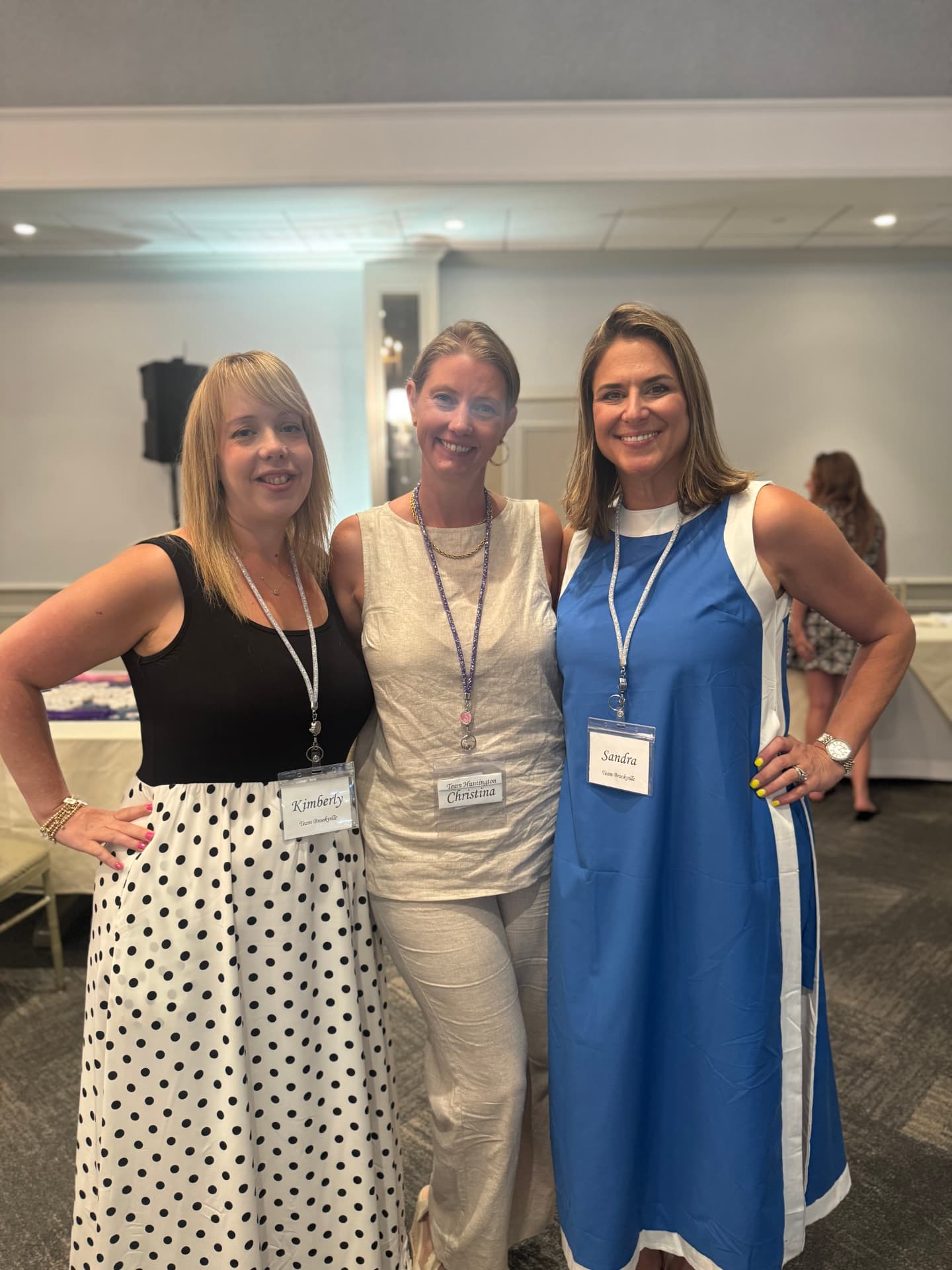 Sandra, Christina and Kimberly standing together wearing team name tags at a mahjong tournament