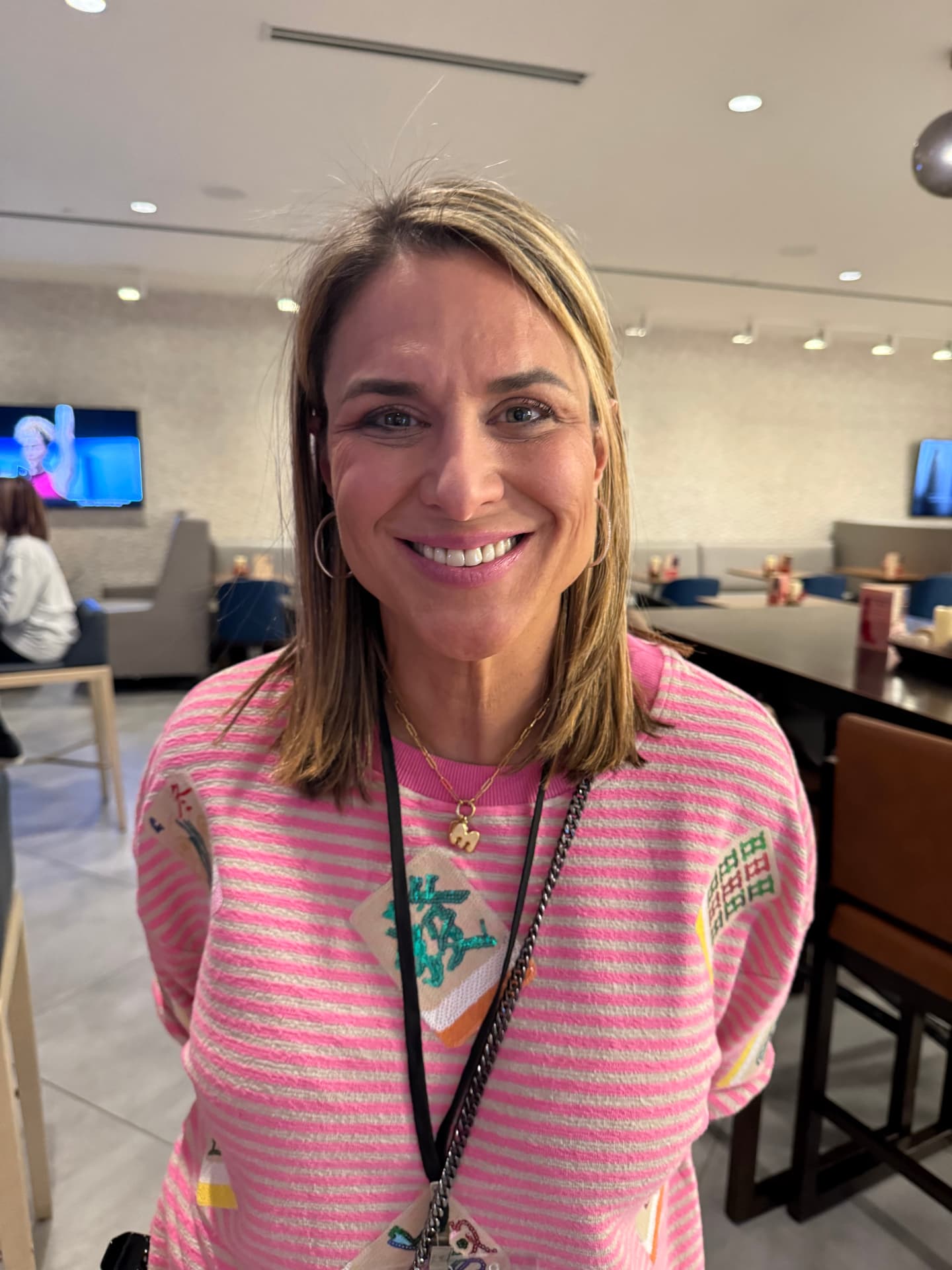 Sandra Mandell smiling in her pink and grey striped Mahjong sweater