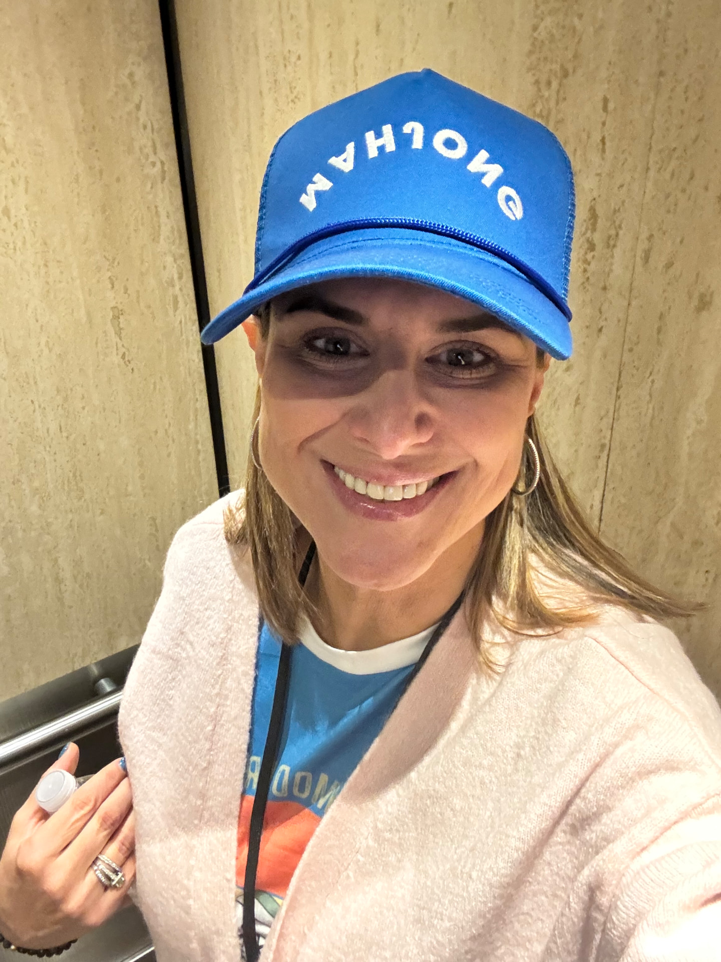 Sandra Mandell smiling in her blue Mahjong cap