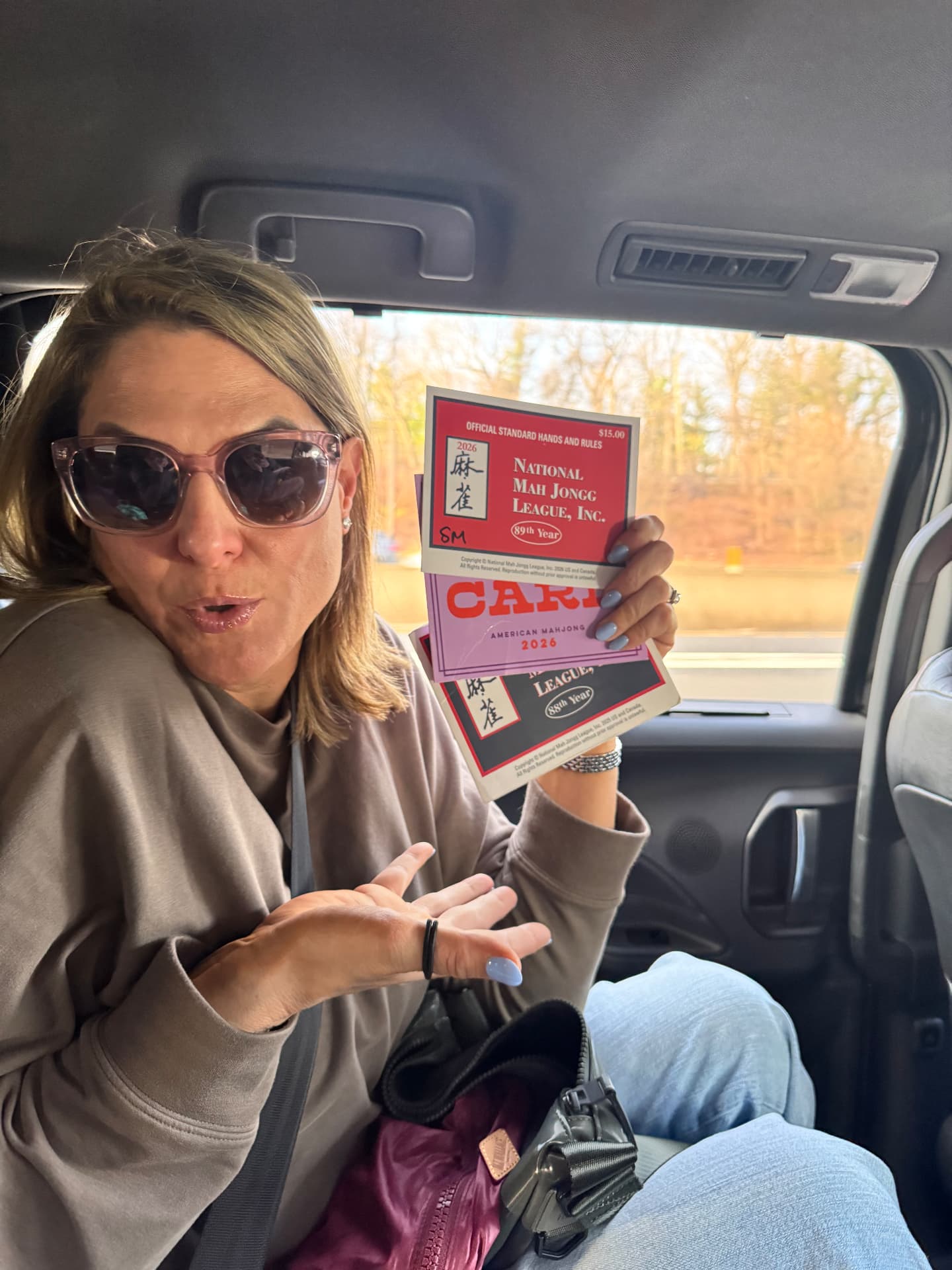 Sandra holding up the newest National Mah Jongg League score cards